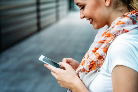 Beautiful business woman using mobile phone outdoors. People communication technology concept.の写真素材