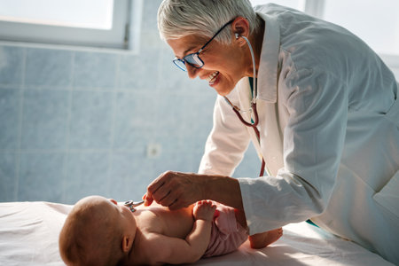 Happy pediatrician doctor with baby checking possible heart defect