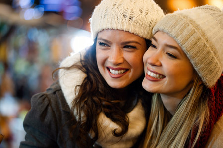 Happy women friends having fun, enjoying moments together in christmas decorated background.の写真素材