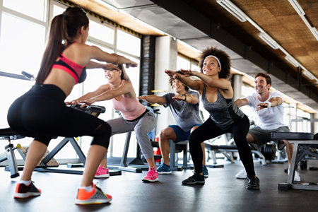 Group of young people, friends smiling and enjoy sport in gym. People exercise, work out concept.の写真素材