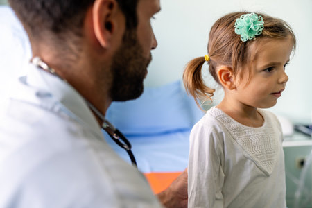 Male doctor examining a child patient in a hospitalの写真素材
