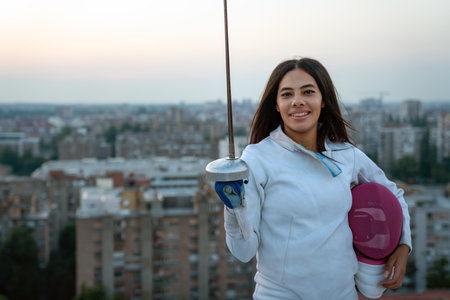 Woman in white fencing costume practicing outdoors. Sport, professional coach, healthy lifestyle.