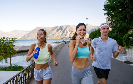 Group of cheerful fit fitness friends team exercising together outdoor. Sport people conceptの写真素材