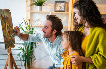 Happy family concept. Young parents with children painting together at home. People fun happyiness.の写真素材