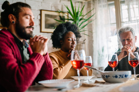 Family and religious concept. Group of multiethnic people with food praying before meal