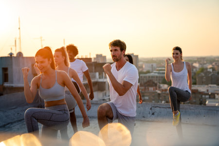 Healthy group of fit multiethnic friends exercising together outdoors. Sport people fun concept.の写真素材