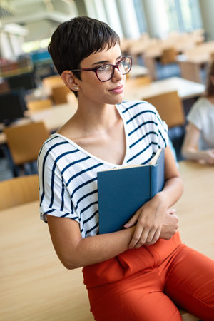 Education library high school university learning people concept. Smiling student girl reading book