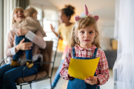 Sad disappointed little girl is jealous because her mom doesnt have time for herの写真素材