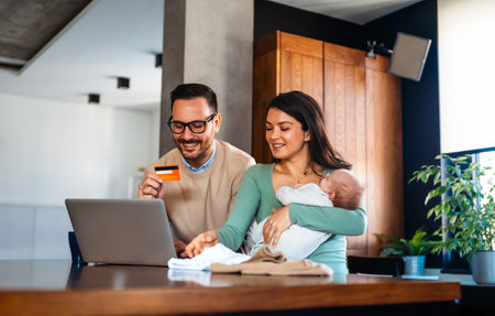 Young family, parents with baby shopping online on laptop with credit card at home. Online shoppingの写真素材