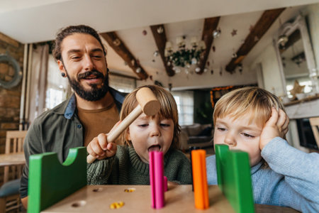 Family, single parent concept. Happy single father and little sons playing with toy blocks at homeの写真素材