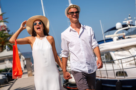 Beautiful young loving couple carrying shopping bags and enjoying travel, vacation together.の写真素材