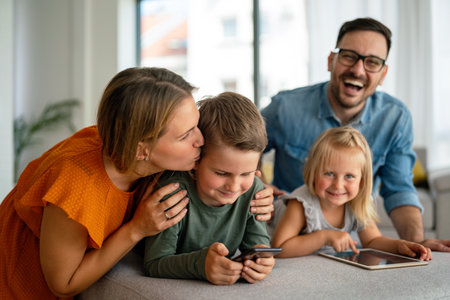 Happy young family having fun time at home. Parents with children using tablet