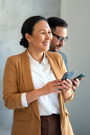 Middle aged asian business woman working on the phone at corporate officeの写真素材