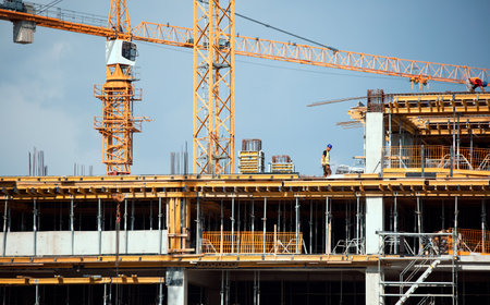Large construction site including several cranes working on a building complex