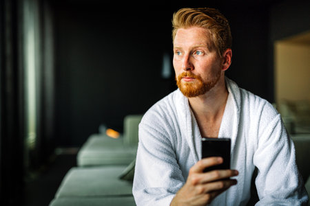 Young man using smart phone for work or to relax and reading news. Social media concept.の写真素材