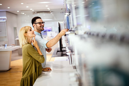 Shopping a new digital device. Happy couple buying a smartphone in store.の写真素材