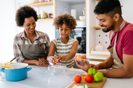 Happy african american parents and child having fun preparing healthy food in kitchenの写真素材