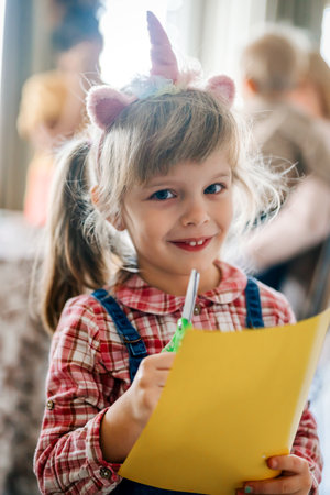 Portrait of happy little girl smiling while her single mother with siblings playing on a backgroundの写真素材