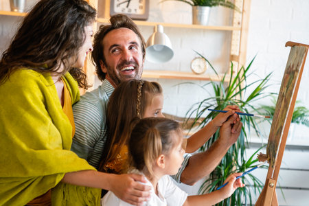 Happy family concept. Young parents with children painting together at home. People fun happyiness.の写真素材