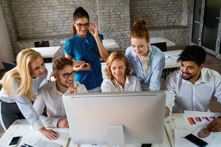 Smiling group of diverse businesspeople working together around a meeting table in an office