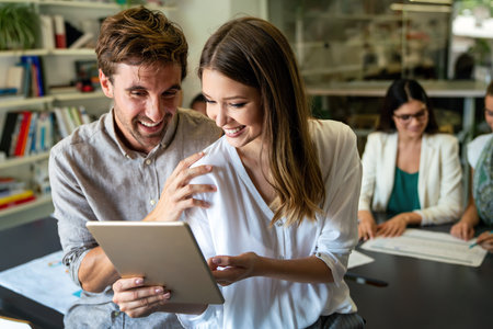 Smiling diverse colleagues gather in boardroom brainstorm discuss financial statistics togetherの写真素材