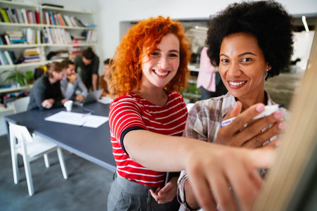 Diverse employees gathered in the office having fun during brainstorming while discussing new ideasの写真素材