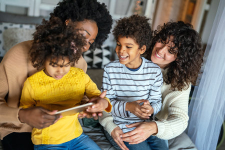 Happy multiethnic family having fun with digital device at home. Family gadget technology concept.