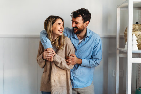 A loving relationship. Beautiful couple hugging and having fun together at home.の写真素材