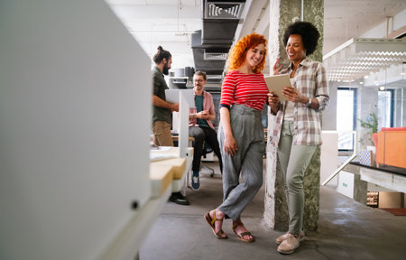 Two businesswoman working together using digital tablet pc and talking about a business project.の写真素材