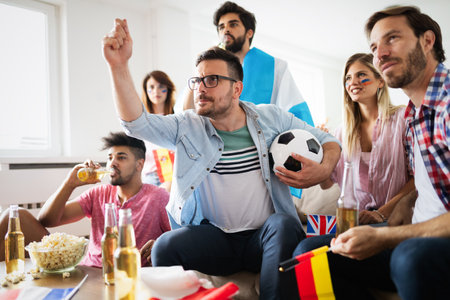 Soccer fans emotionally watching game in the living room.の写真素材