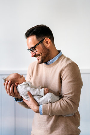 Loving father carrying of his newborn baby at home. Family parenting baby single father love concept