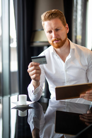 Happy successful business man doing online shopping or satisfied entrepreneur making online paymentの写真素材