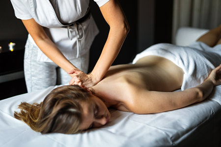 Young happy Caucasian woman relaxing with hand massage at beauty wellness spa salonの写真素材