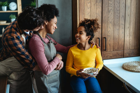 Overjoyed young multiethnic family with daughter having fun in kitchen together