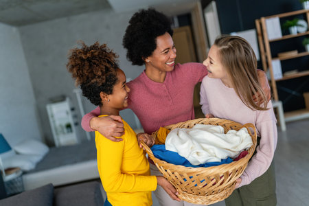 Happy multiethnic teenage children are smiling while do household with mother at home.の写真素材