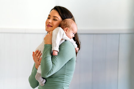 Loving single mother carrying of her newborn baby at home. People love care family concept