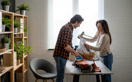 Happy young mixed race couple doing the ironing together at home