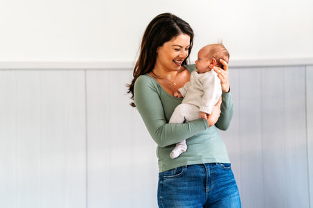 Loving single mother carrying of her newborn baby at home. People love care family concept