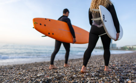 Young beautiful couple of friends on the sea with surfboards in their hands, sports active lifestyleの写真素材