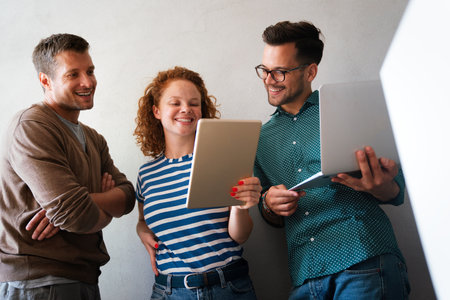 Group of young multi-ethnic startup business team collaborating on project in modern office