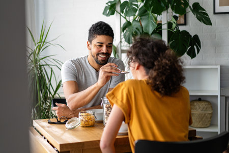 Happy african american couple in love having breakfast together in the kitchenの写真素材