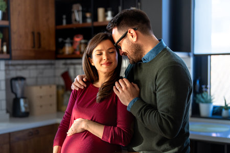 Man in love hugs his pregnant wife, they are waiting together for the babys arrival. Love, family