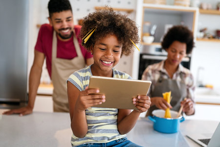 Happy african family having fun with device at home. Black parents and child using digital tabletの写真素材
