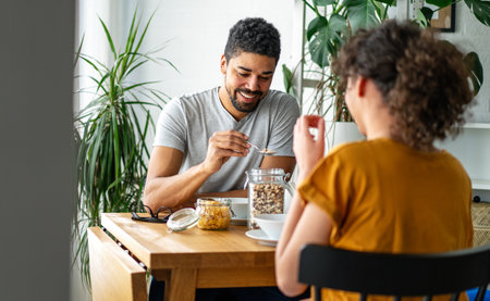 Happy couple having breakfast together in the kitchenの写真素材