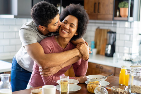 Happy african american couple having breakfast together in the kitchenの写真素材