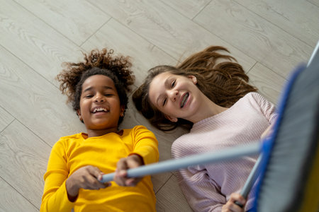 Happy multiethnic teenage children are smiling while do household at home.の写真素材