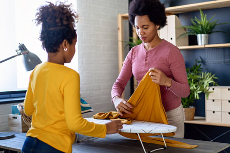 Happy african american child helping for mother do household and domestic chores togetherの写真素材