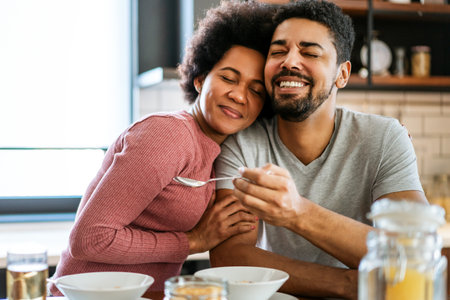 Happy african american couple having breakfast together in the kitchenの写真素材