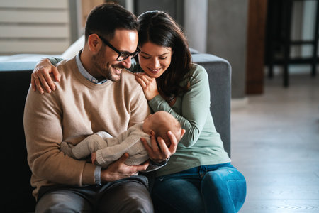 Family, adoption, baby, parenthood and people concept. Happy mother father with newborn baby at homeの写真素材