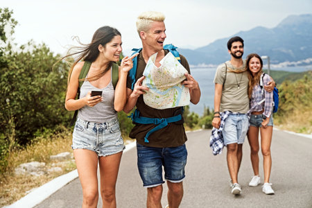 Friendship, travel, vacation, summer and people concept. Group of smiling friends with map travelingの写真素材